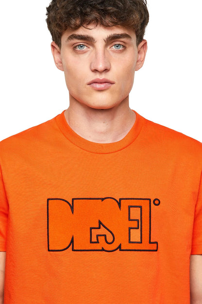Orange crewneck T-shirt close-up of black Diesel logo on chest
