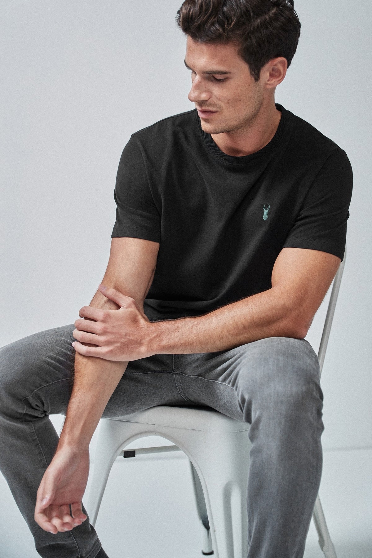 Black men's T-shirt with small chest logo, short sleeves and crew neck.