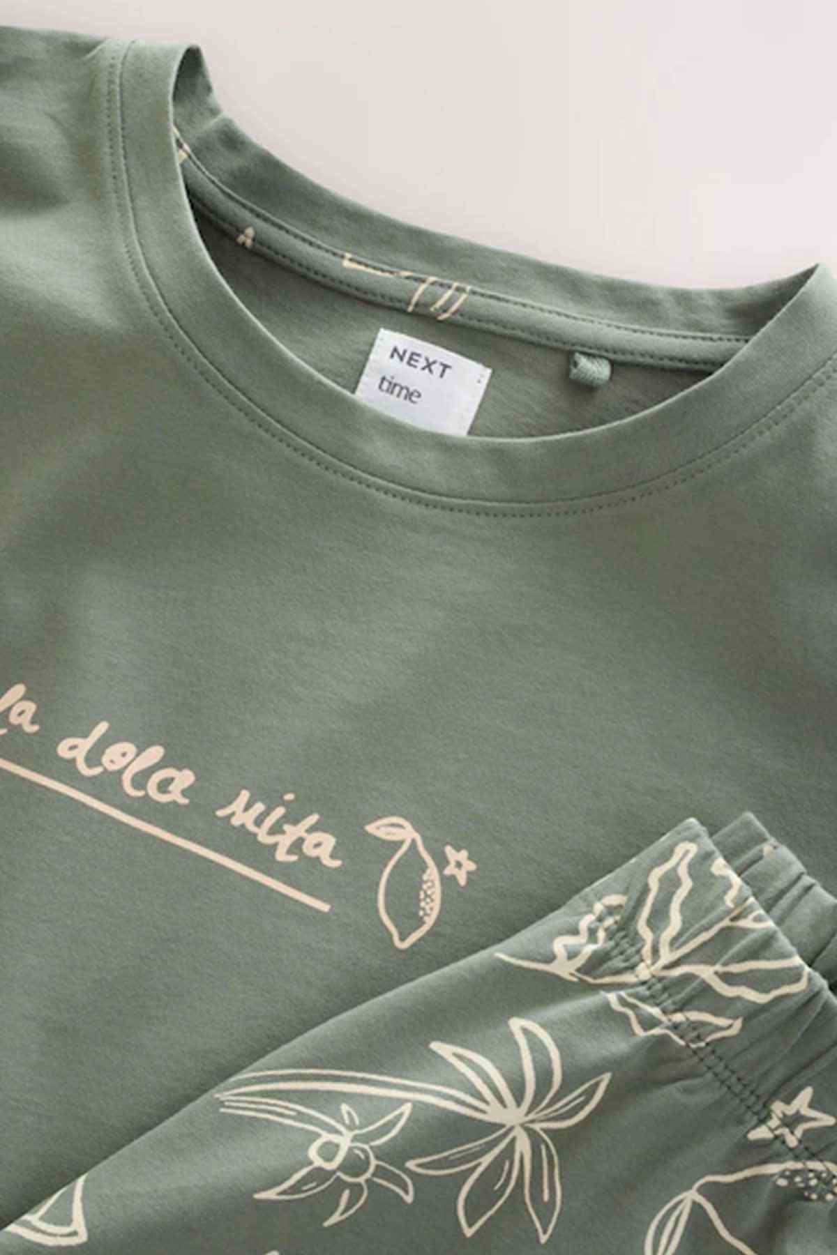 Sage green crew-neck T-shirt neckline with white graphic text print