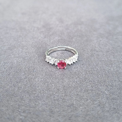 Silver-tone ring with red oval center gemstone and white fringe detailing