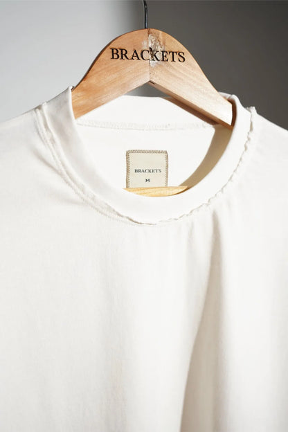 Off-white T-shirt with round neck and red bracket graphic at chest