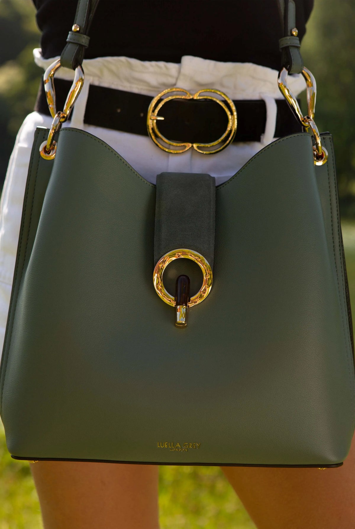 Green hobo bag with gold-ring center clasp, top handles, and logo stamp