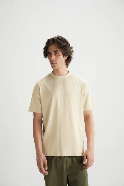 Beige short-sleeve crewneck T-shirt on male model with dark green pants