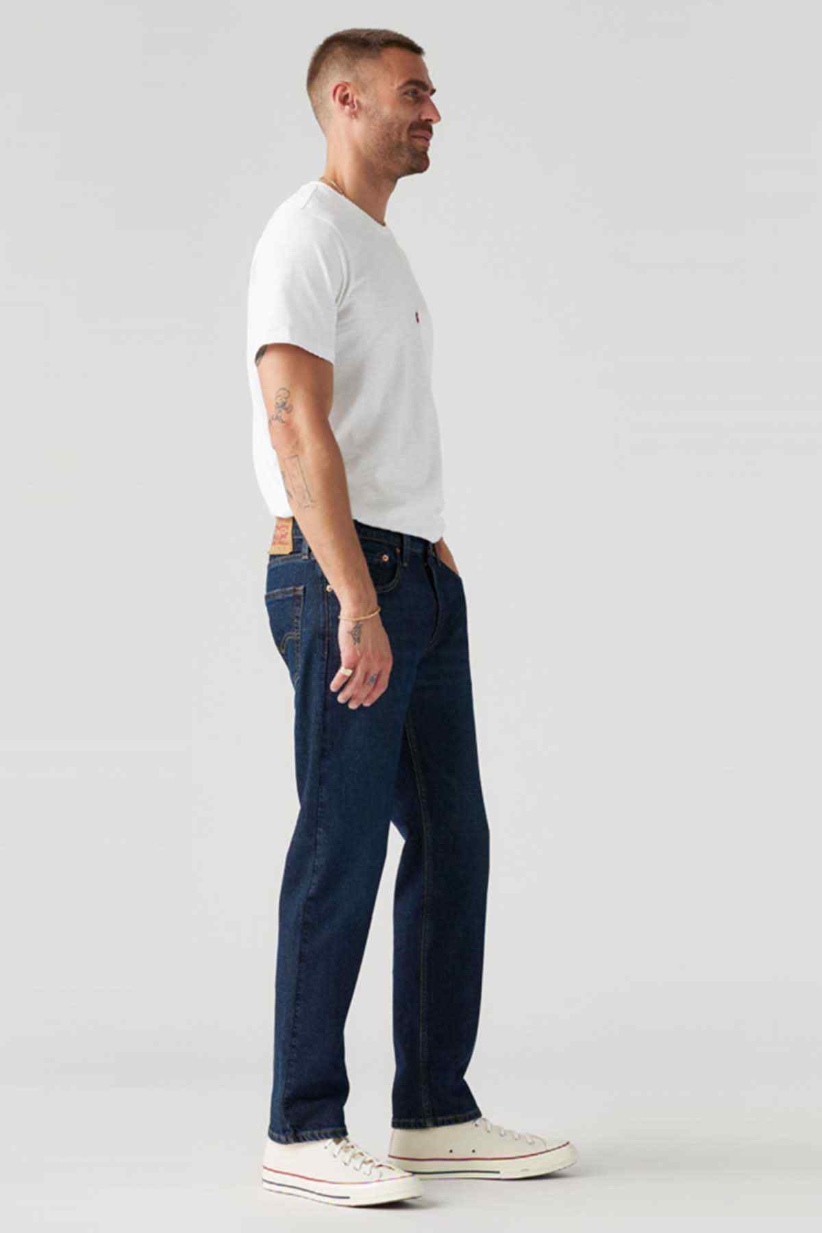 Dark indigo denim jeans with straight leg, five-pocket design, side view