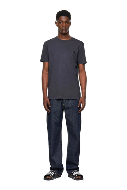 Men's dark Diesel T-shirt with crewneck and small chest logo, worn with jeans