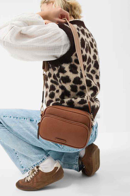 Tan leather-look crossbody bag with leopard-print strap and zip front pocket