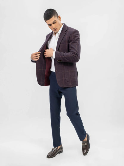 Men's burgundy plaid blazer worn open over a white shirt with navy pants