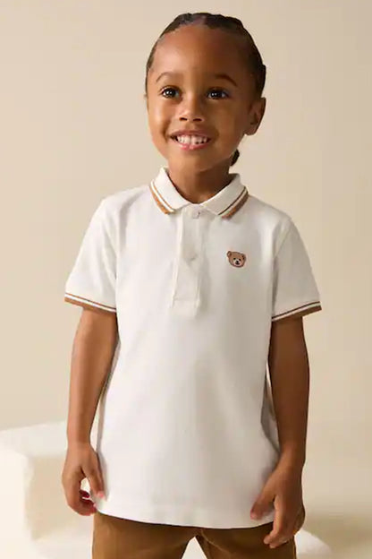 Children's white polo shirt with brown-striped collar and teddy bear chest patch