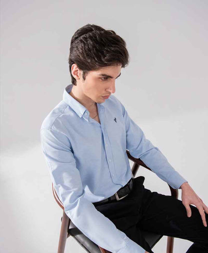 Light blue fitted button-up shirt, long sleeves with button cuffs and chest logo.