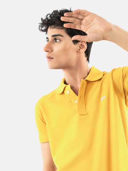 Yellow cotton polo shirt with short sleeves, button placket, and small chest logo