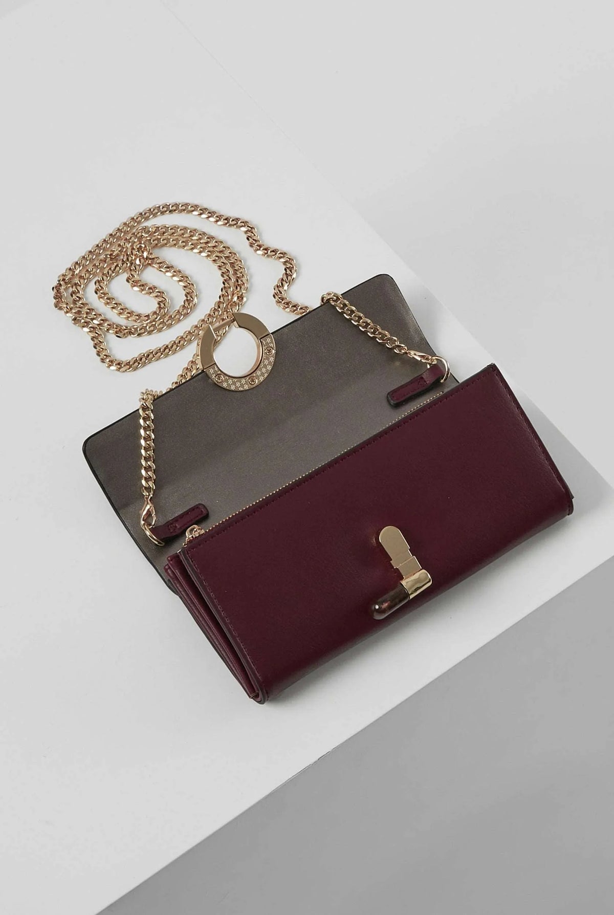Berry foldover wallet with gold-tone chain strap and round ring clasp, bar accents