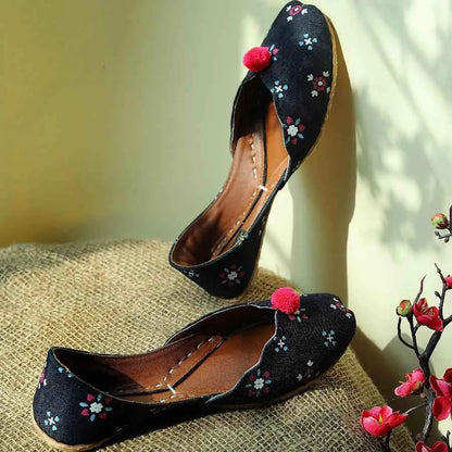 Embroidered dark flats with floral pattern and red pom-poms, pointed toe