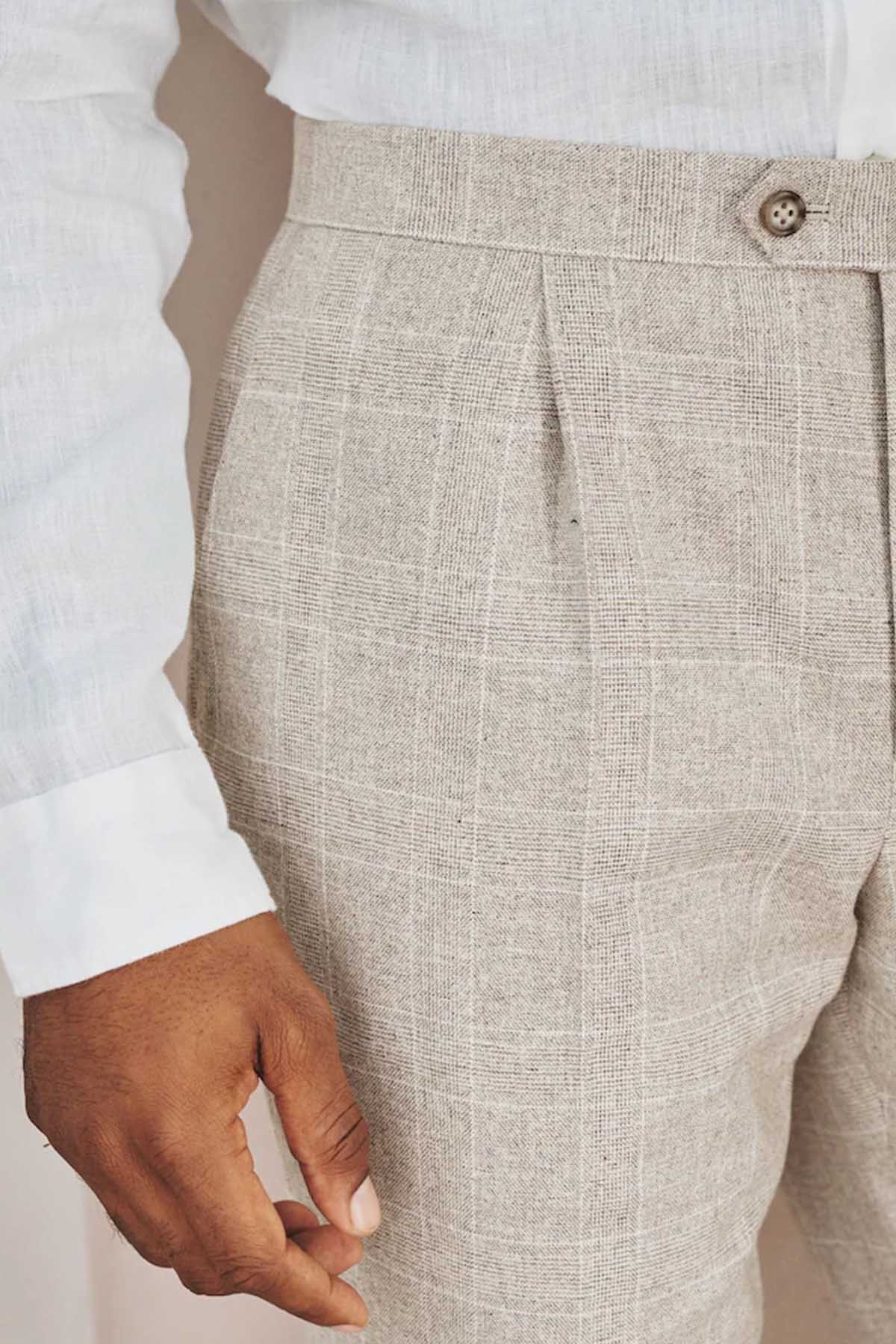 Men's suit trouser front pocket and waistband seam, light beige textured fabric