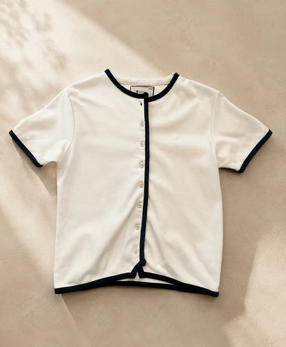Fitted cream button-front top with navy-trimmed crew neck and short sleeves