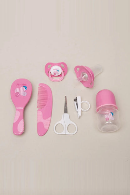 Pink baby grooming kit: brush, comb, pacifier, nail clippers, and bottle