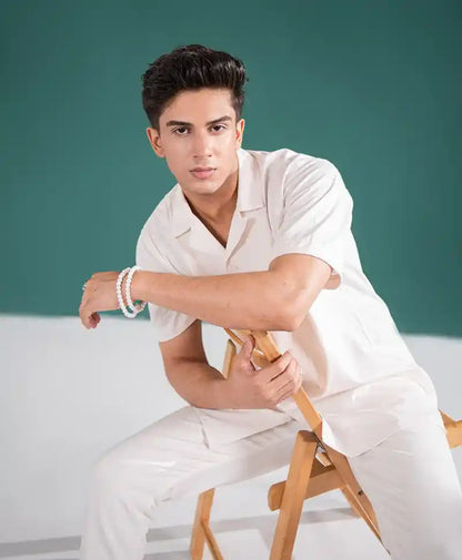 Off-white fitted short-sleeve shirt with V-neck and button front, paired pants
