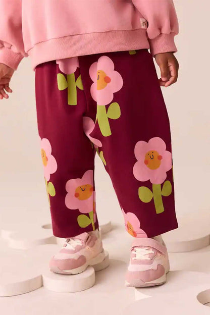 Burgundy floral kids pants with elastic waist and straight legs, close-up
