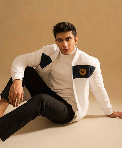Men's white zip-up bomber jacket with black sleeve and chest panels, logo patch