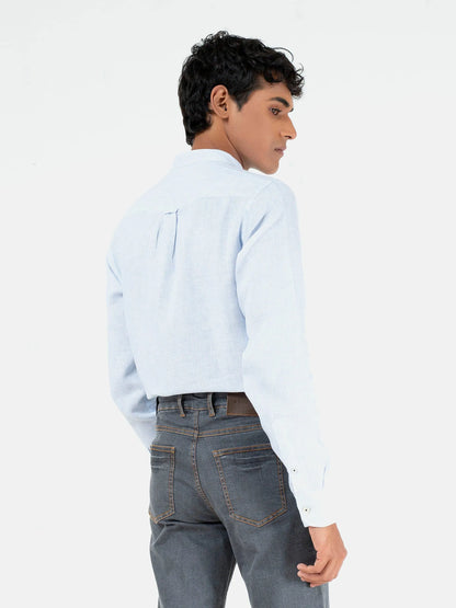 Men's light blue button-up shirt, side view, long sleeves, button front.