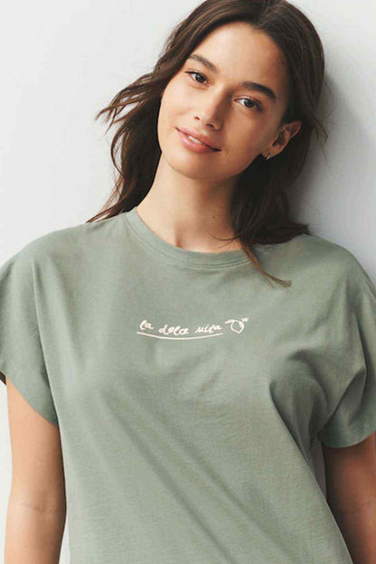 Sage green crew-neck T-shirt with small white logo-style graphic on chest