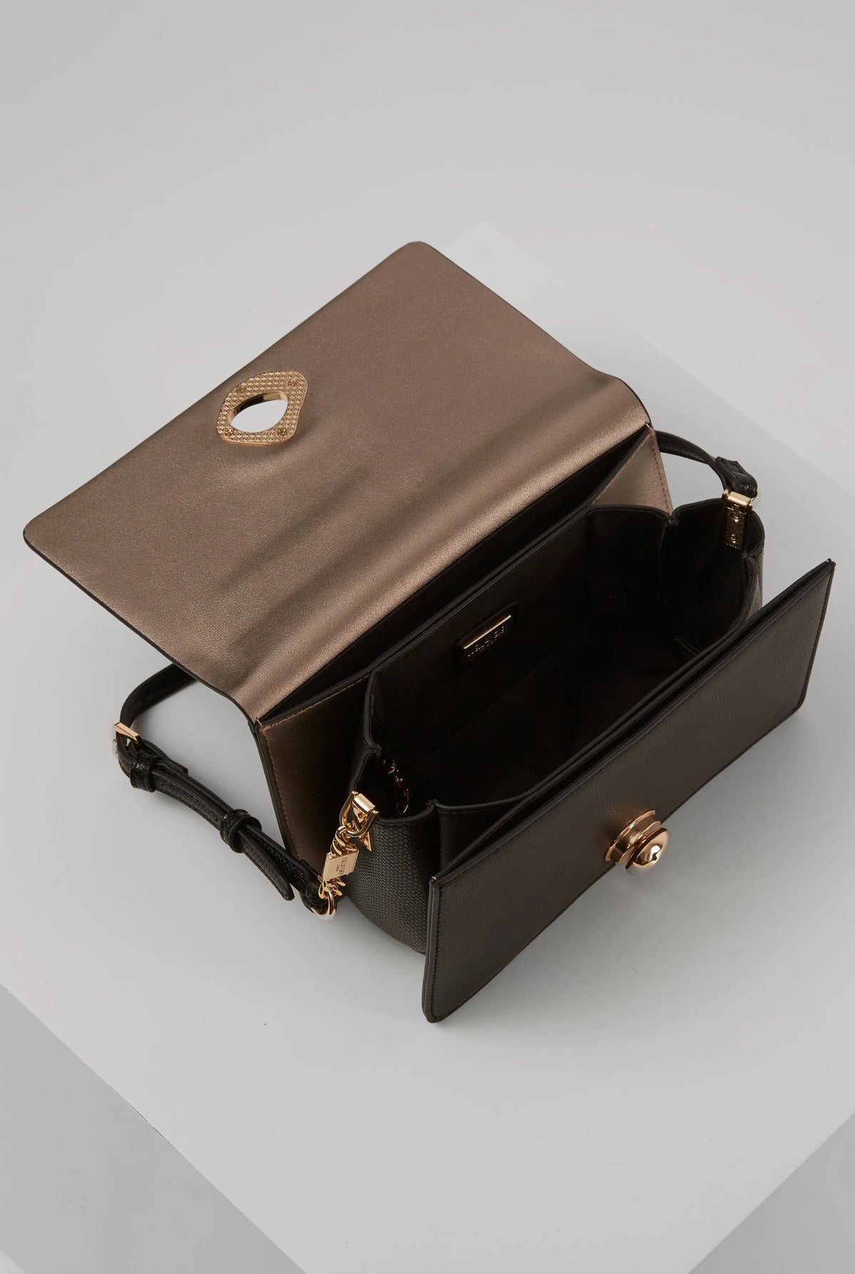 Black shoulder bag open view with interior compartments and gold emblem hardware