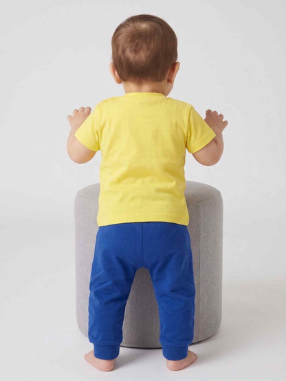 Baby outfit: yellow T-shirt and navy jogger pants set, rear view on chair