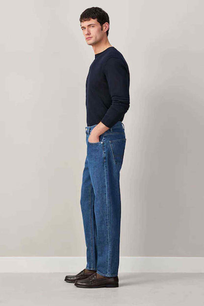 Men's mid-blue denim jeans, side view, straight fit with button fly