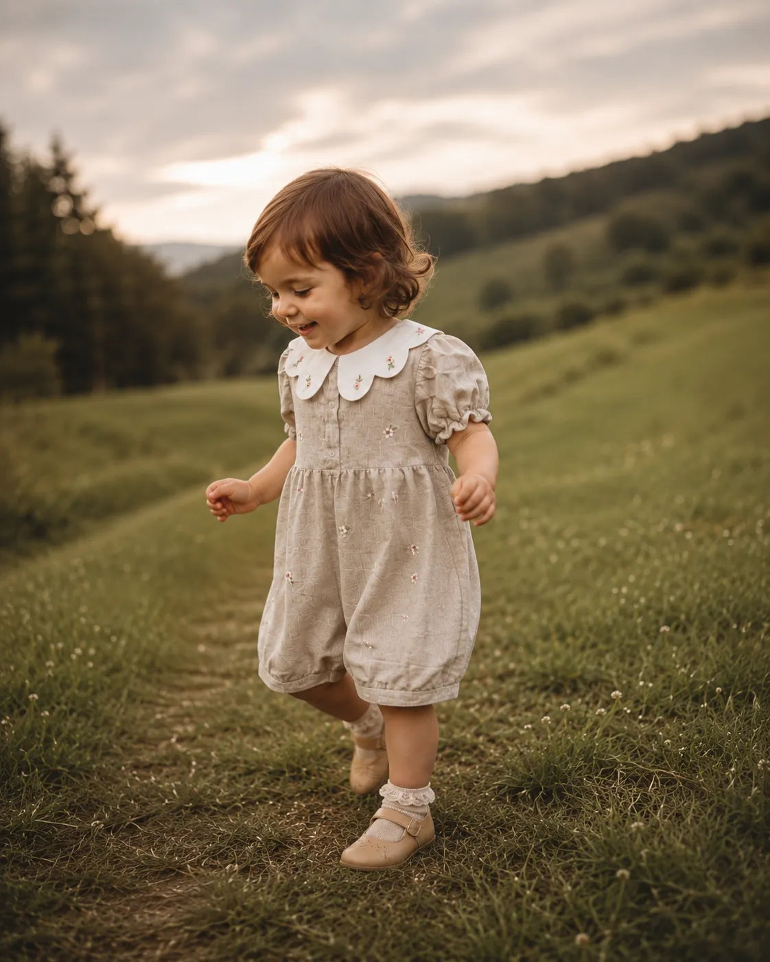 Stone baby romper with white Peter Pan collar and button-front floral details