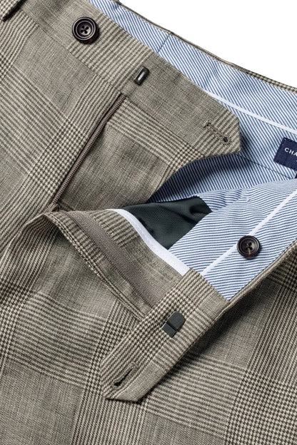 Suit trousers close-up: plaid fabric, dark buttons, contrast striped inner pocket