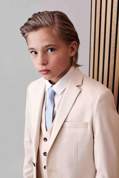 Cream blazer with chest pocket and button front, paired with blue tie and vest