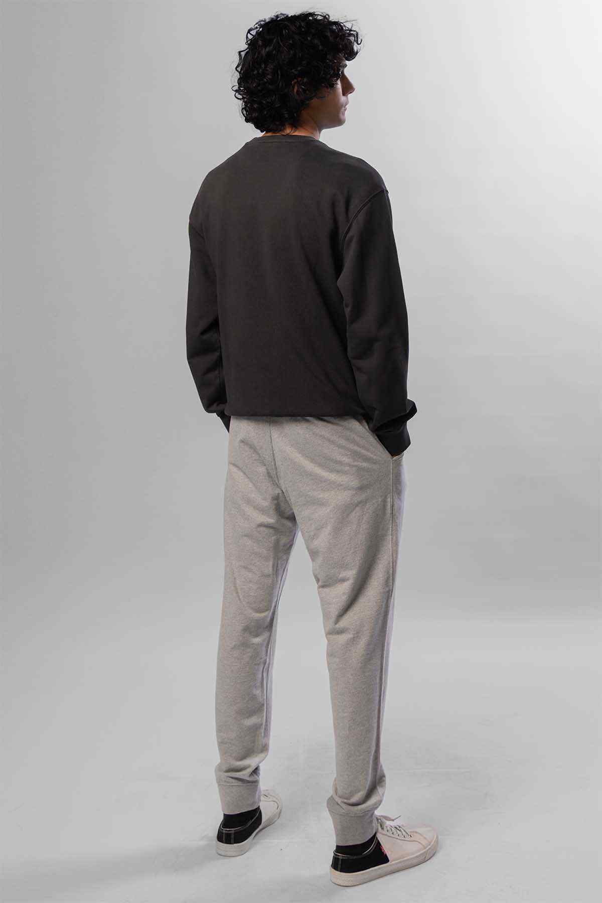 Levi's logo crewneck sweatshirt and light grey tapered jogger pants, back view