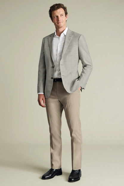 Men's neutral slim trousers on model, tailored fit with belt and cuffs