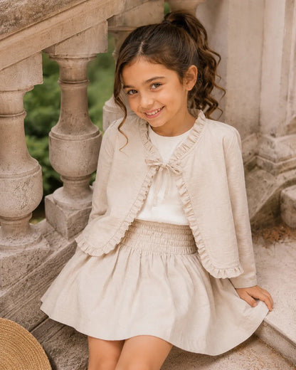 Beige girls dress with ruffle trim, smocked yoke, and gathered hem