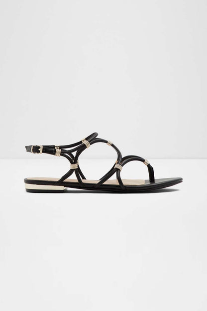 Black flat sandal with crisscross straps and gold-tone ring accents
