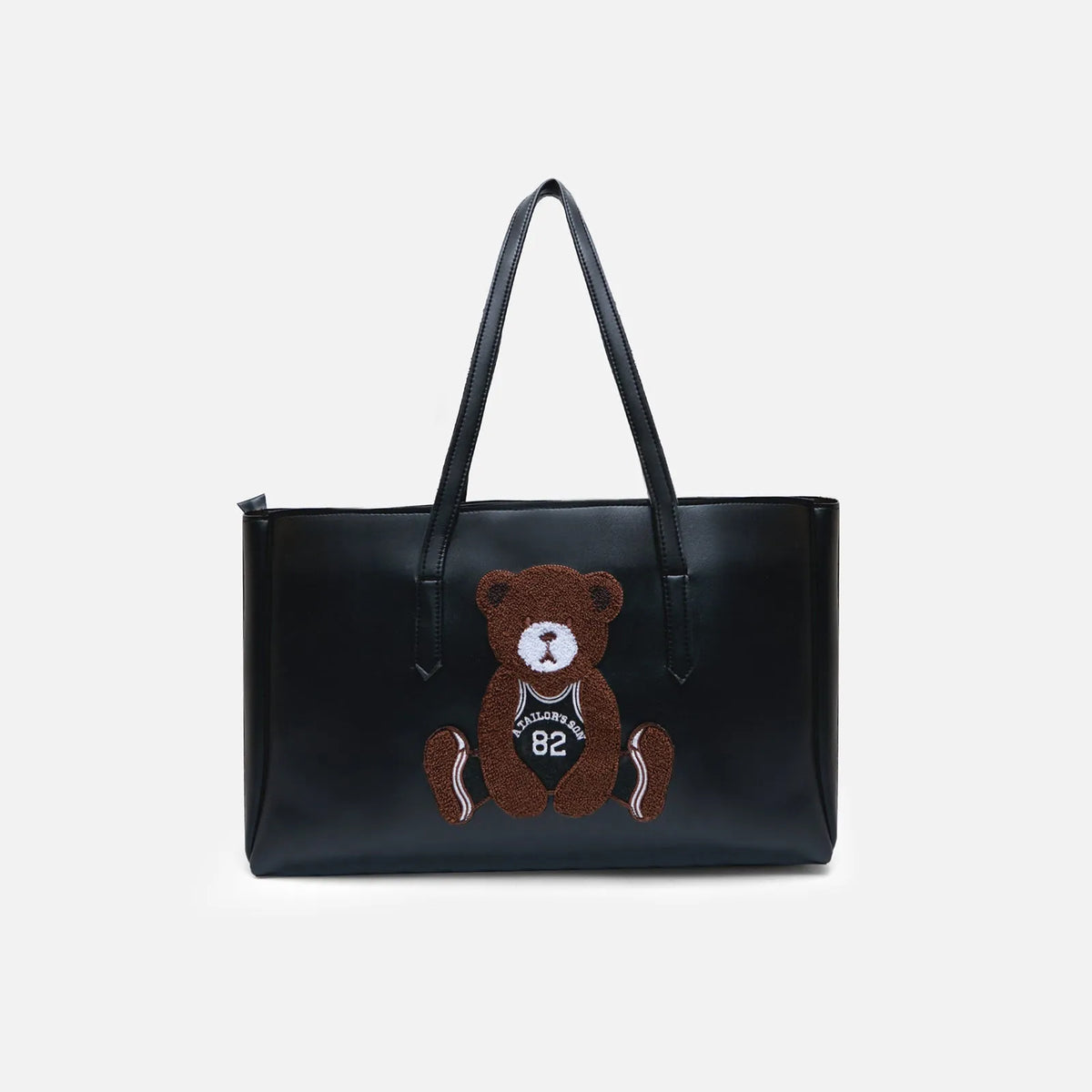 Black faux-leather tote bag with teddy bear applique front and long handles