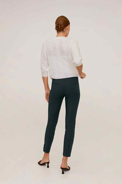 MANGO white knit cardigan and dark green ankle trousers, back view