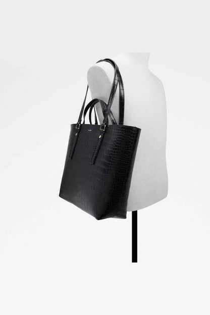 Black embossed tote bag on mannequin with two top handles and front pocket