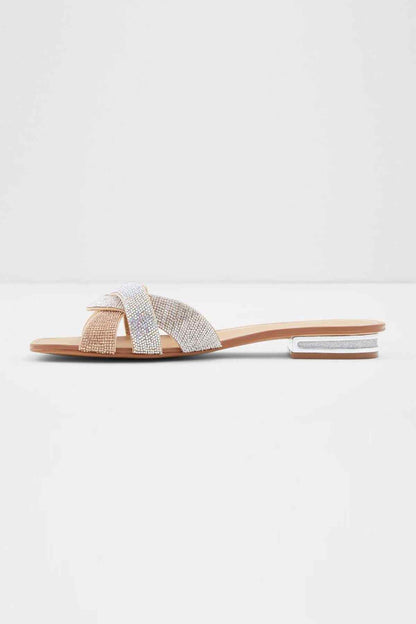 Bone rhinestone slide sandals with wide strap and open toe, angled side view