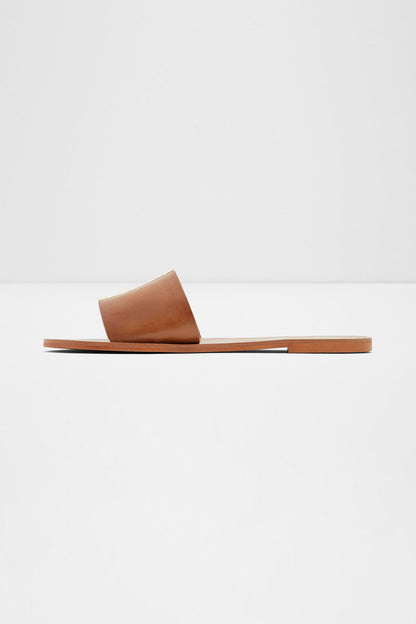 Brown leather slide sandal with open toe and single wide strap on flat sole