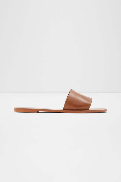 Brown leather slide sandal with wide toe strap and flat sole