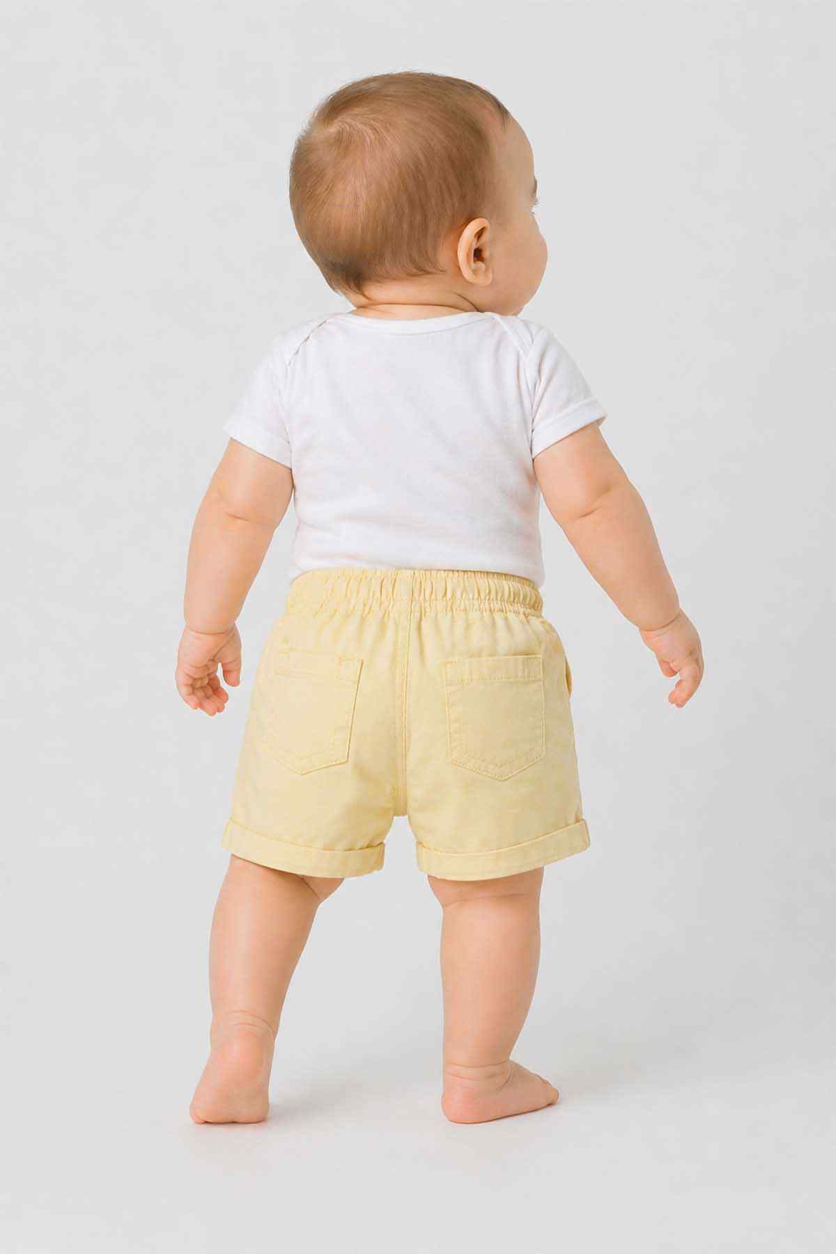 Yellow baby shorts on baby, elastic waistband and drawstring, back view