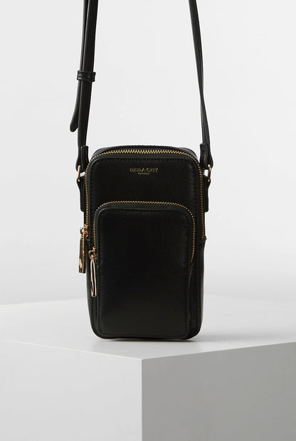 Black crossbody bag with top zipper and dual straps, gold-tone hardware and front panel