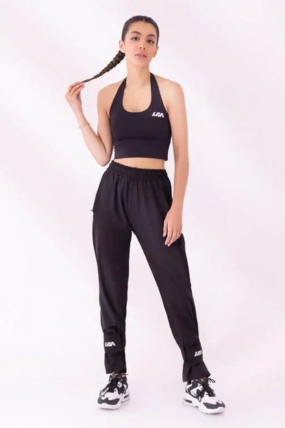 Black halter sports bra and black jogger pants with logo at hem