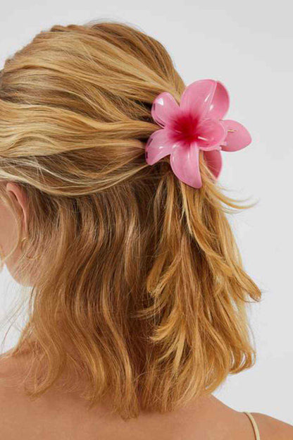Fuchsia flower hair clip with layered petals on blonde hair