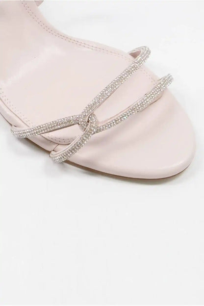 Ecru sandal straps with rhinestone trim across the top and ankle