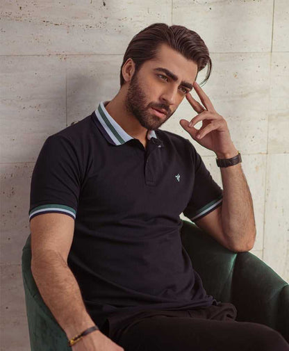 Men's dark polo shirt with striped collar and sleeve cuffs, small chest logo