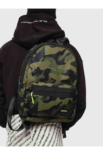 Diesel green camo mini backpack worn over a black hoodie