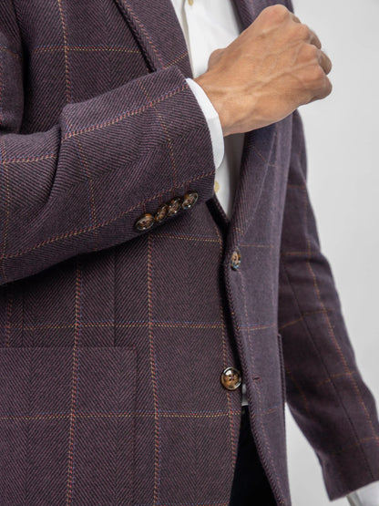 Close-up of burgundy plaid blazer cuff and gold-tone button details