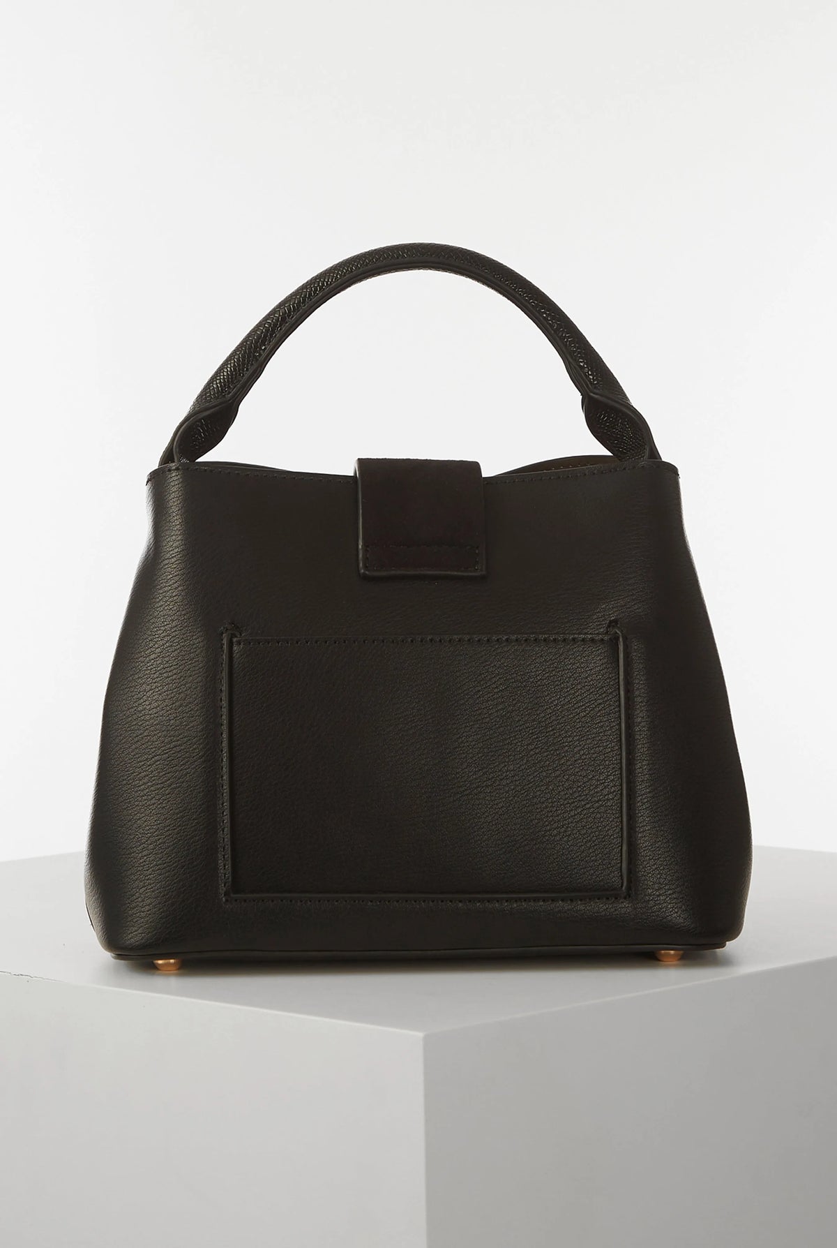 Black structured handbag with top handle and front flap pocket with snap
