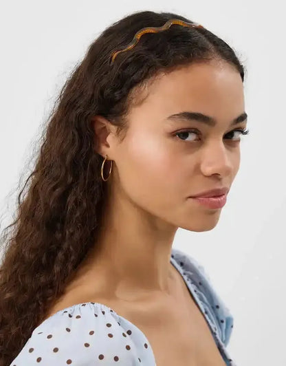 Tortoiseshell-effect headband with wavy dark brown and amber pattern